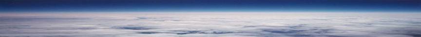 The horizon with blue skies and white clouds over the earth below